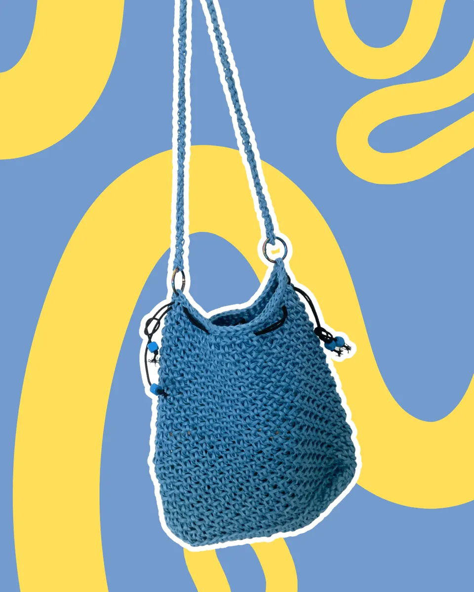 Borsa a Secchiello Crochet "Ocean Vibe" — Aggiungi un tocco boho-chic al tuo look con questa borsa a secchiello interamente lavorata all'uncinetto in una splendida tonalità blu avio. Caratterizzata da una trama artigianale resistente e leggera, è rifinita con una chiusura a coulisse impreziosita da dettagli di perline e da una comoda tracolla sottile. Pratica, versatile e capiente al punto giusto: l'accessorio perfetto per dare personalità ai tuoi outfit quotidiani.