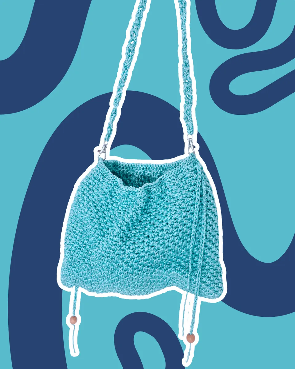 Borsa Crochet "Turquoise Breeze" — Fresca, estiva e ricca di dettagli! Questa borsa a sacchetto è realizzata interamente all'uncinetto in un incantevole turchese brillante. Presenta una ricca lavorazione a grana di riso che dona struttura e morbidezza al tempo stesso. Completano il design una comoda tracolla intrecciata rimovibile tramite moschettoni e dei cordini laterali rifiniti con eleganti perline in legno naturale per un tocco boho-chic.